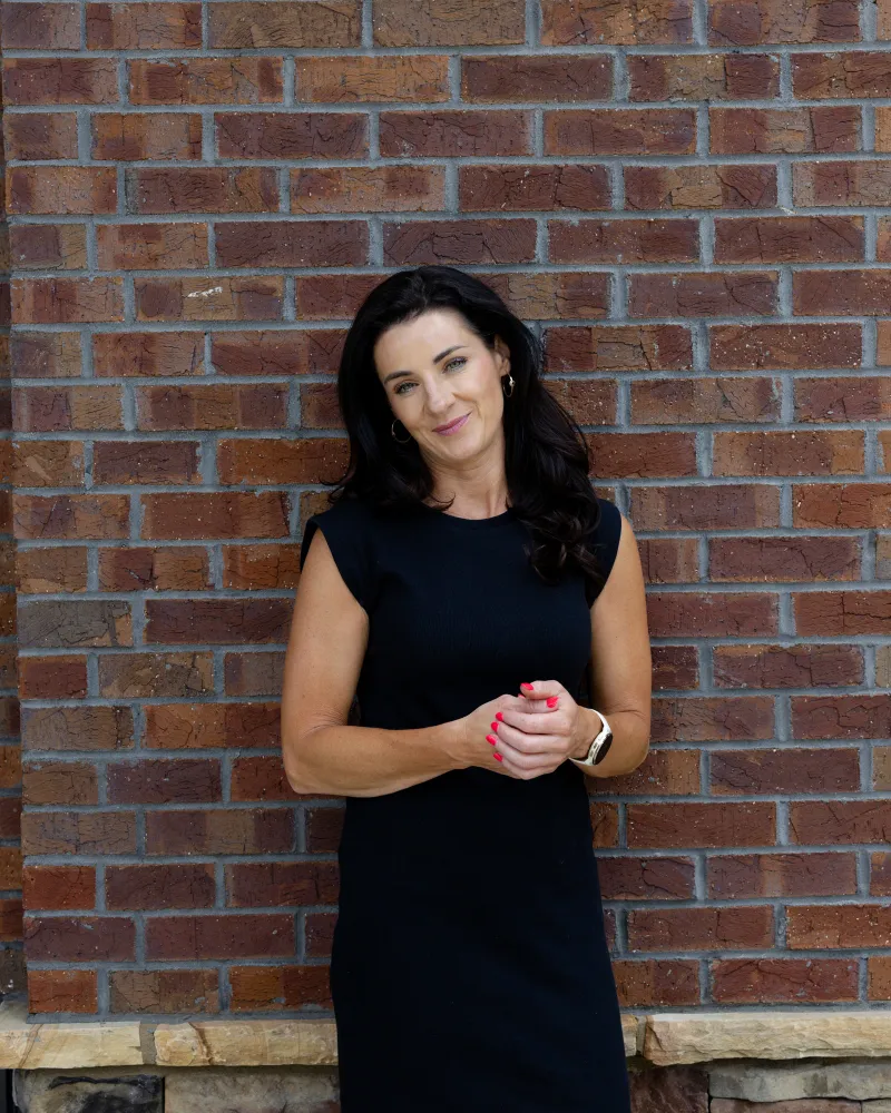 Claire O'Connor standing in front of a brick wall